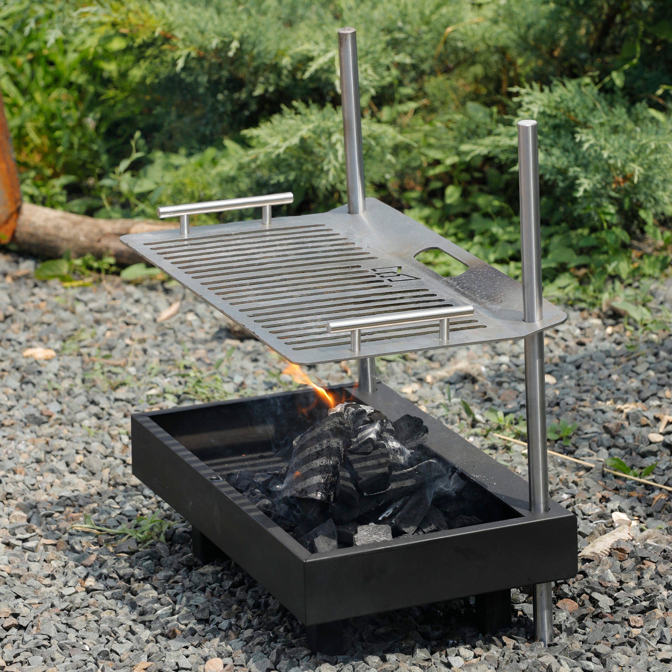 Grătar portabil 1 MAI din oțel și oțel inoxidabil, design compact și reglabil, ideal pentru camping, picnicuri și gătit în aer liber. Ușor de curățat și întreținut.